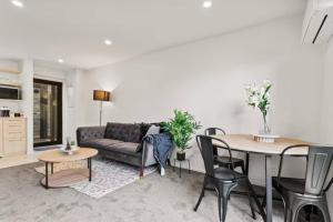 a living room with a couch and a table at Auckland Peninsula Stunner in Auckland