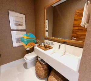 a bathroom with a sink and a toilet and a mirror at Villa Biarritz, Praia do Forte in Praia do Forte +26 photos