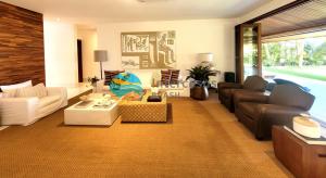 a living room with a couch and a table at Villa Biarritz, Praia do Forte in Praia do Forte