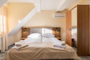 a bedroom with a large bed with white sheets and pillows at Hotel Perła Dunajca in Czarny Dunajec