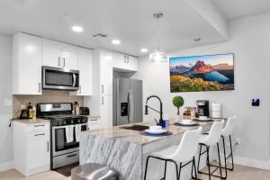タルサにあるModish 1BR - BOK, Near Blue Dome, Pets Allowedの白いキャビネット付きのキッチン、椅子付きのキッチンアイランド