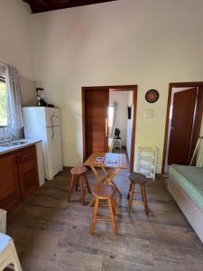 eine Küche mit Tisch und Hockern in einem Zimmer in der Unterkunft Kitnet Pinheira - Praia de Cima in Palhoça