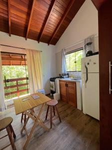 eine Küche mit einem Tisch und einem Kühlschrank in der Unterkunft Kitnet Pinheira - Praia de Cima in Palhoça