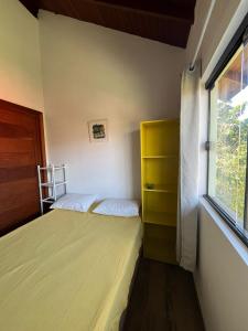 ein kleines Schlafzimmer mit zwei Betten und einem Fenster in der Unterkunft Kitnet Pinheira - Praia de Cima in Palhoça