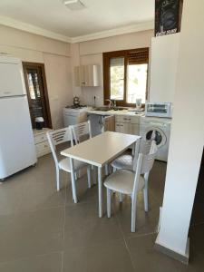 a kitchen with a table and chairs and a refrigerator at Villa Sunrise in Izmir