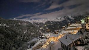 una città con montagne innevate sullo sfondo di Charming 6 bed chalet in 4 Valleés a Iserables