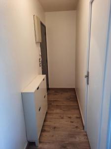 an empty room with a white cabinet and a hallway at Les Buttes - Apt 4 Prs, 1 ch - Parking privé in Dijon +5 photos