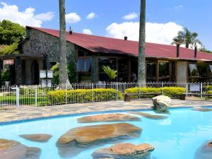 a swimming pool with rocks in front of a building at Panaroma View in Graskop