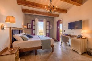 een slaapkamer met een bed, een bureau en een televisie bij Mulberries in Żabbar