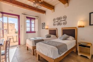 een slaapkamer met 2 bedden en een tafel bij Mulberries in Żabbar +159 foto's