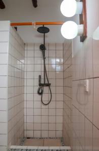 a shower in a white tiled bathroom at Mtwapa Mj Villa Marina in Mombasa
