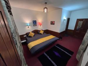 a bedroom with a bed with yellow and blue sheets at Basecamp Manali in Manāli