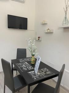 a black dining room table with chairs and a tv at Casa Vacanza Rosati in Cerignola