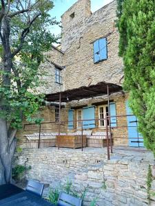 a large stone building with a fence in front of it at La maison Haut-perché townhouse with view and jacuzzi in Saumane-de-Vaucluse