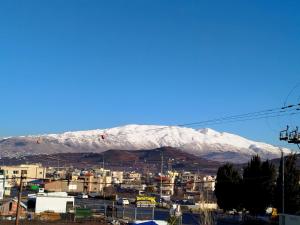 a mountain covered in snow in a city at Hotel Boutique 98 in Buq‘ātā