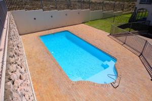 ランゲバーンにあるLuxury Sunset Heights Unit 79のレンガ造りのパティオ付きの大型スイミングプール