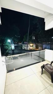 a black bench sitting on top of a balcony at night at Coastal Bliss Appartments in Varkala