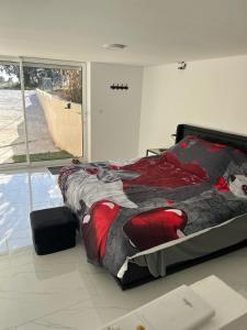 Schlafzimmer mit einem Bett mit einer roten und schwarzen Decke in der Unterkunft Love room in Camaret-sur-Aigues