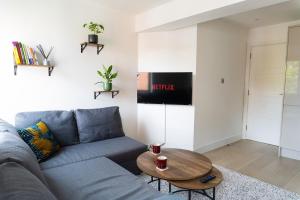 a living room with a blue couch and a table at 1Bed Gem, Quick Access to Windsor, Central London in Slough
