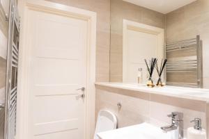 a bathroom with a toilet and a sink and a mirror at 1Bed Gem, Quick Access to Windsor, Central London in Slough