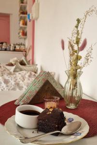 a piece of chocolate cake on a plate with a cup of coffee at NILAY House Varanasi Near Assi Ghat in Varanasi
