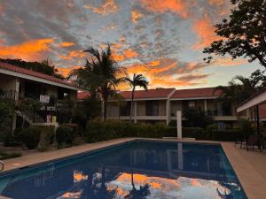a pool in front of a building with a sunset at Casa Rosa del Mar in Coco