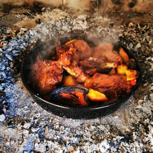 a pan filled with chicken cooking on a grill at Kuća za odmor Tomislav in Trnovdc +19 photos