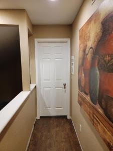 a hallway with a white door and vases on the wall at 420 Friendly CRNRM Nad's Place in Highlands Ranch