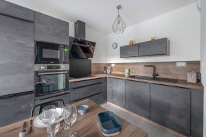 a kitchen with a table with wine glasses on it at Appartement pour 4 à 150m de la Mer in Sainte-Marie +12 photos