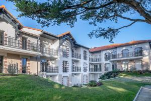 an exterior view of a building with a green lawn at Appartement pour 4 à 150m de la Mer in Sainte-Marie
