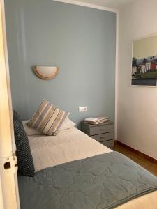 ein Schlafzimmer mit einem Bett mit einem Kissen und einem Nachttisch in der Unterkunft Tossa de Mar - TROPICANA in Tossa de Mar