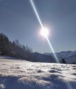 a sun shining in the sky over a snow covered field at Le Panoramic 1300 - Proche La Plagne in Notre-Dame-du-Pré