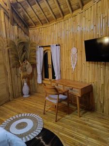 a living room with a piano and a television at JinengBali Eco Lodge in Tegalalang