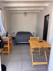 Un dormitorio con una cama y una mesa y una mesa y sillas. en Monoambiente, en Monte Hermoso