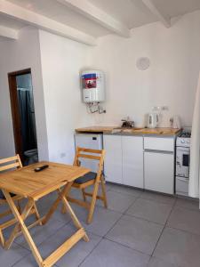 una cocina con mesa de madera y sillas. en Monoambiente, en Monte Hermoso