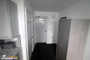 a small bathroom with a closet and a door at Jayden House in Middlesbrough