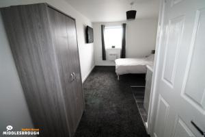a room with a closet and a bedroom with a bed at Jayden House in Middlesbrough