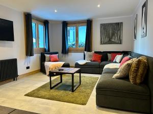 a living room with a couch and a table at 4 Bedroom, 4 Bathroom, Hot Tub, Chamonix Centre in Chamonix-Mont-Blanc