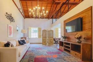 a living room with a couch and a flat screen tv at Casa em São João Del Rei conforto e charme in São João del Rei