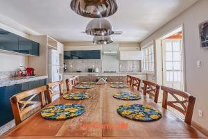 a kitchen with a long wooden table with chairs at Casa em São João Del Rei conforto e charme in São João del Rei