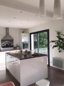 a white kitchen with a sink and a stove at Maison de Charme in Colomiers