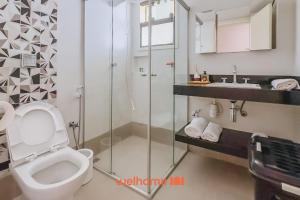 a bathroom with a toilet and a glass shower at Casa em São João Del Rei conforto e charme in São João del Rei