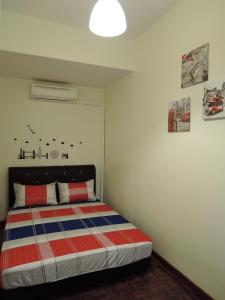 a bedroom with a bed with a striped blanket at The Pillohouzzze in Melaka