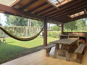 a wooden picnic table under a pavilion with a hammock at Agréable maison bien située in Capbreton