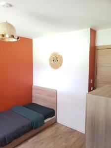 a bedroom with a bed with an orange and white wall at Agréable maison bien située in Capbreton
