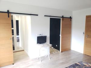 a room with a desk and a computer on a table at Agréable maison bien située in Capbreton