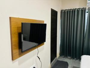 ein Flachbildfernseher an einer Wand in einem Raum in der Unterkunft Hotel StayInn in Kozhikode