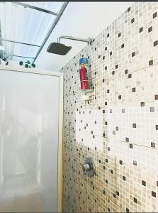 a shower with a red fire extinguisher on a tile wall at Casa Josefina Allende Nuevo Leon in Allende +19 photos