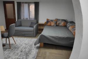a bedroom with a bed and a couch and a chair at Studio Maljković in Knjazevac.