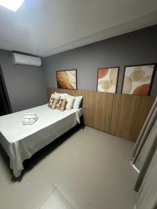 a bedroom with a bed with white sheets and pillows at Beach Haus beira mar bessa in Tambaú